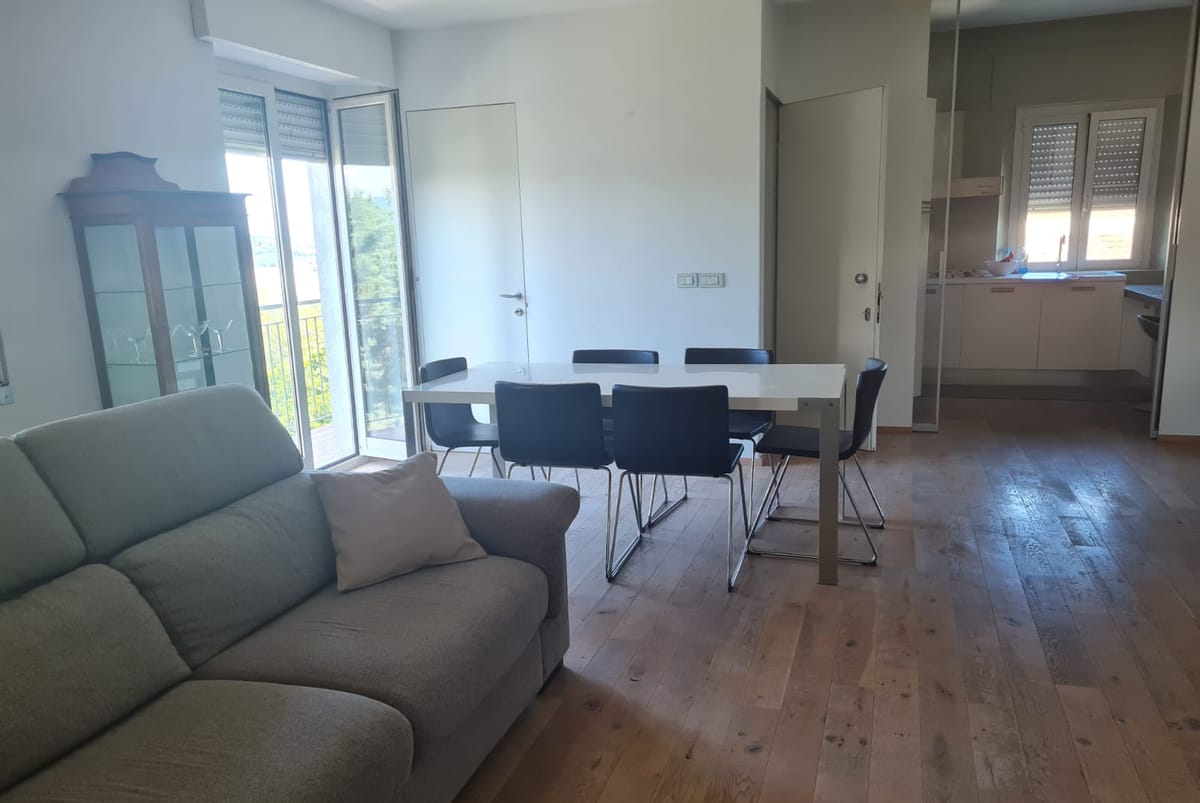 Living area of the Sun Apartment with sofa, dining table and kitchen